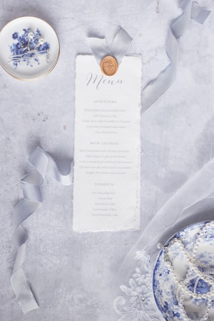 A stack of refined menus with restrained design elements, tied together with a simple ribbon.