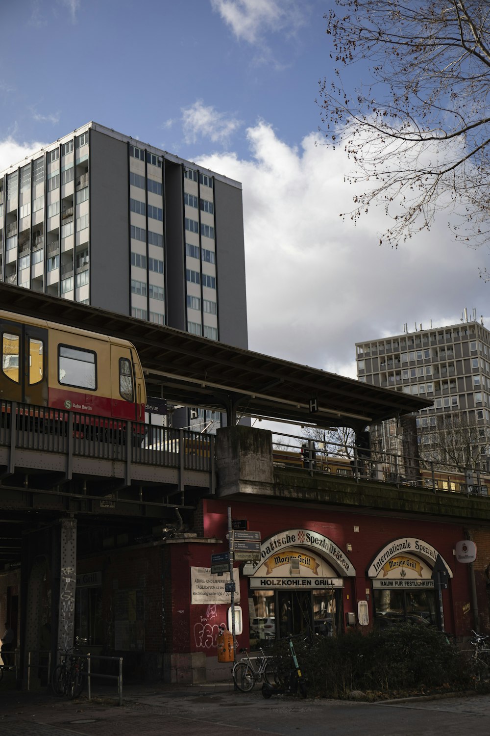 a train traveling over a bridge next to a tall building