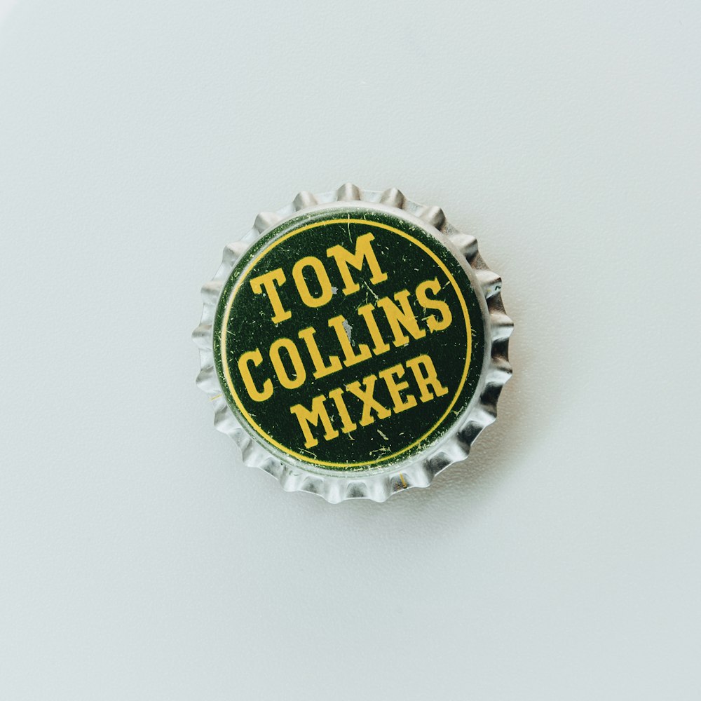 a bottle cap with the words tom collins's mixer on it