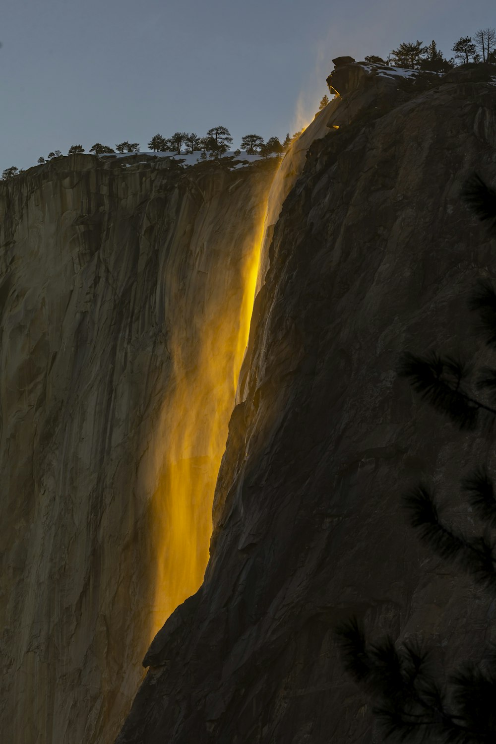 a tall waterfall with a bright light coming from it