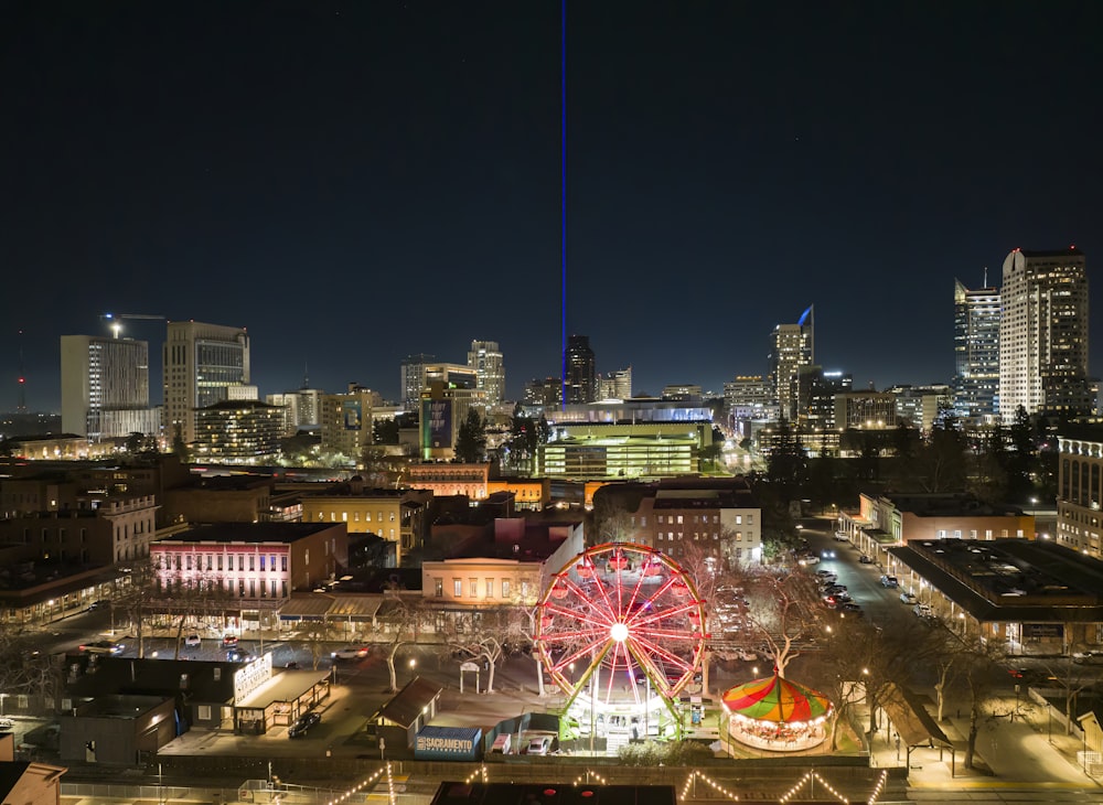 a ferris wheel in the middle of a city at night