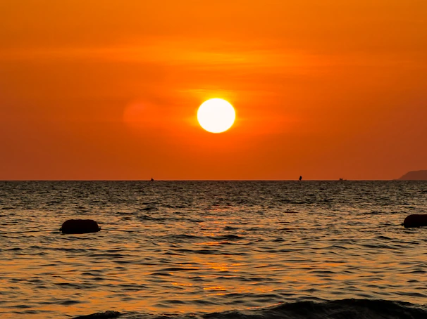 A vibrant sunrise over a calm sea reflecting orange and pink hues