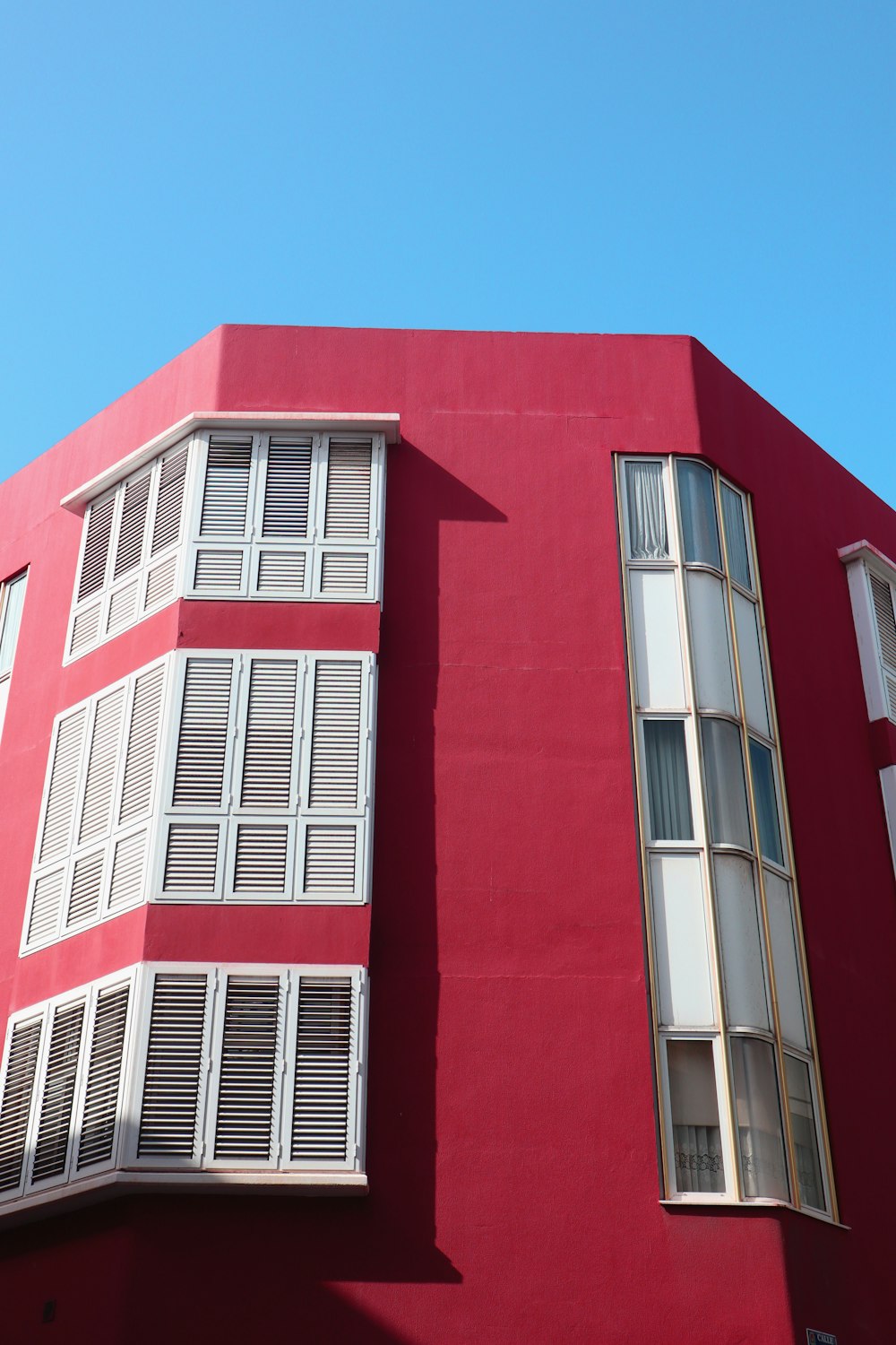 a red building with white windows and shutters