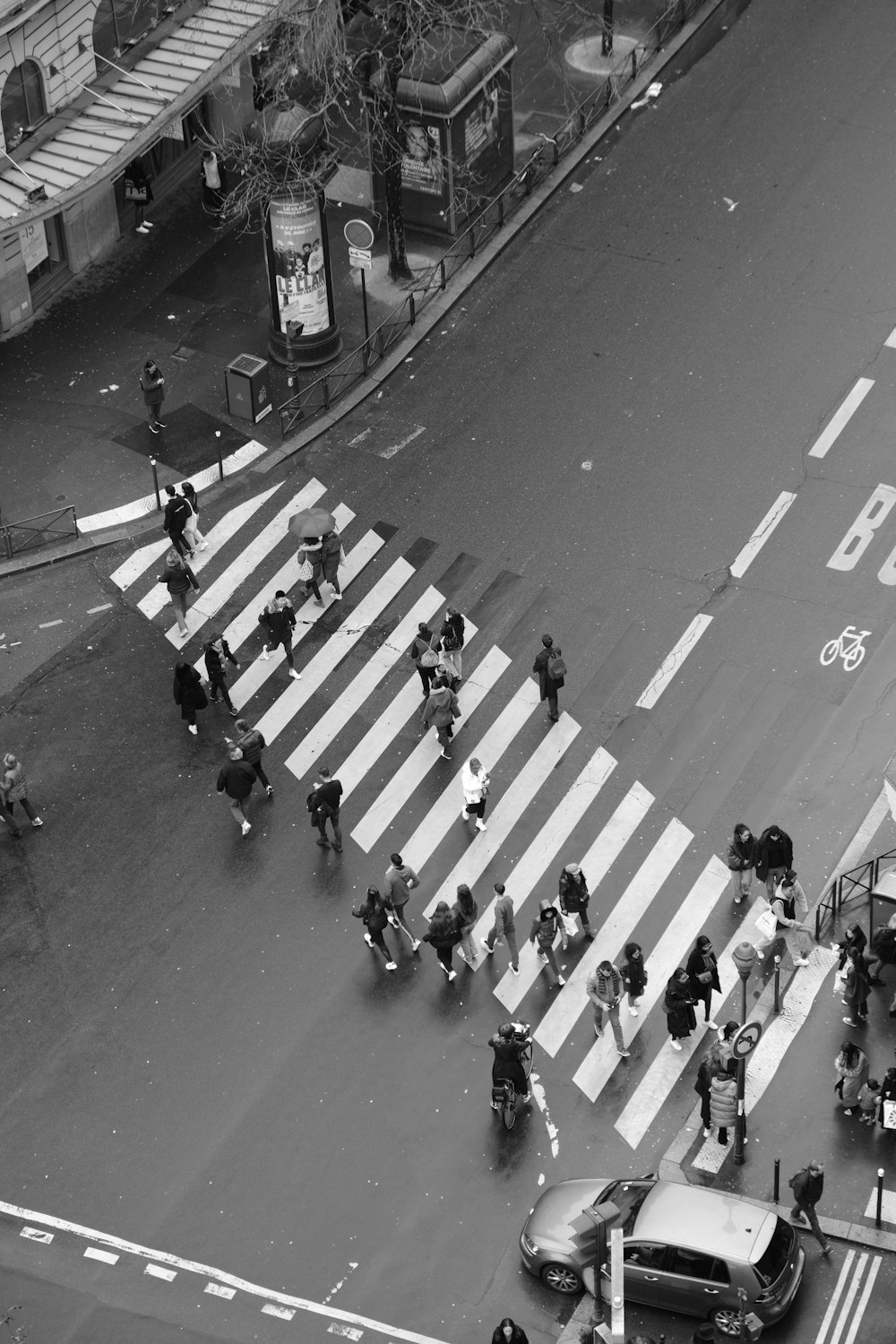 a black and white photo of people crossing the street
