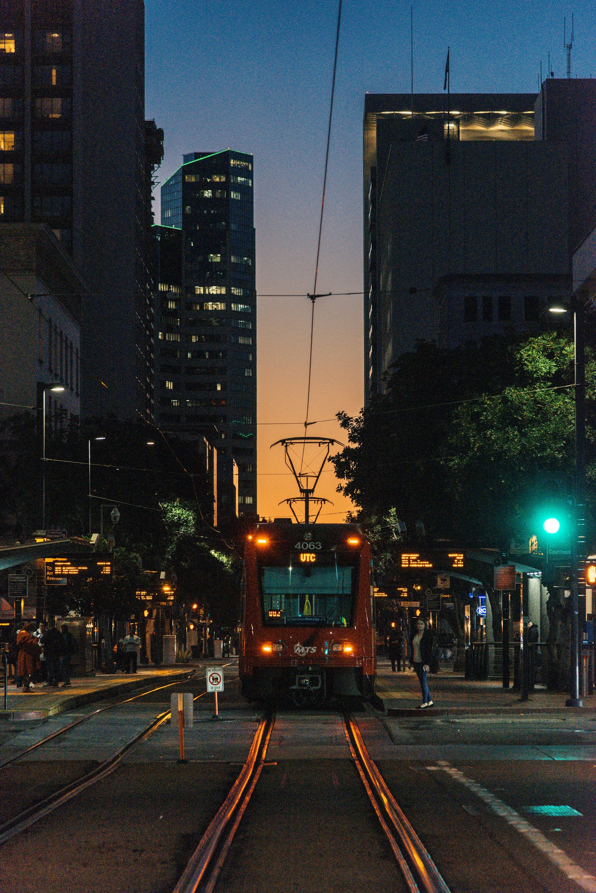 An evening shot showing the glowing LED lights outlining the trolley, with a group celebrating a birthday under city lights.
