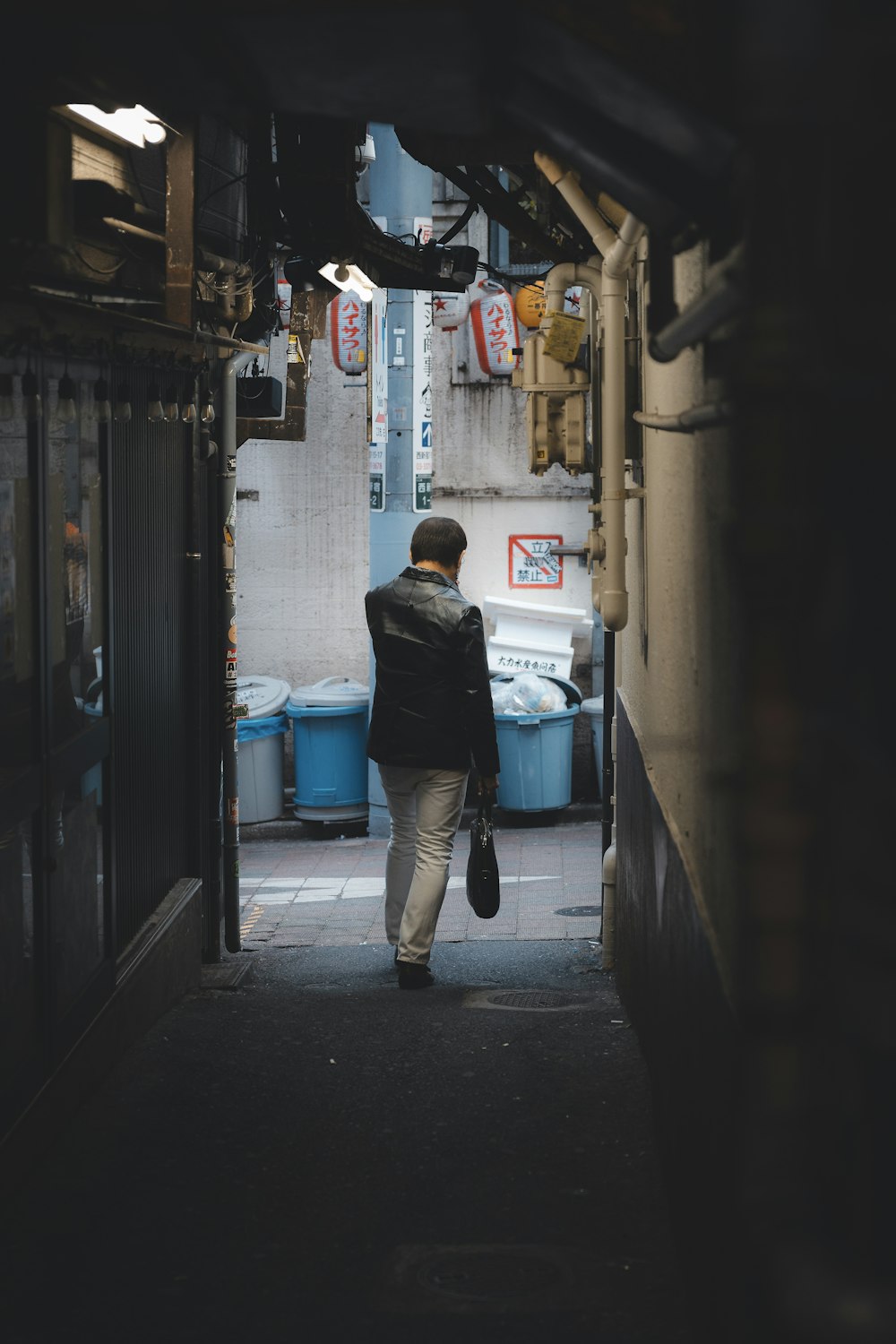 a person walking down a narrow alley way