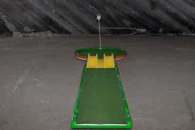 a green and yellow miniature golf course in a parking lot