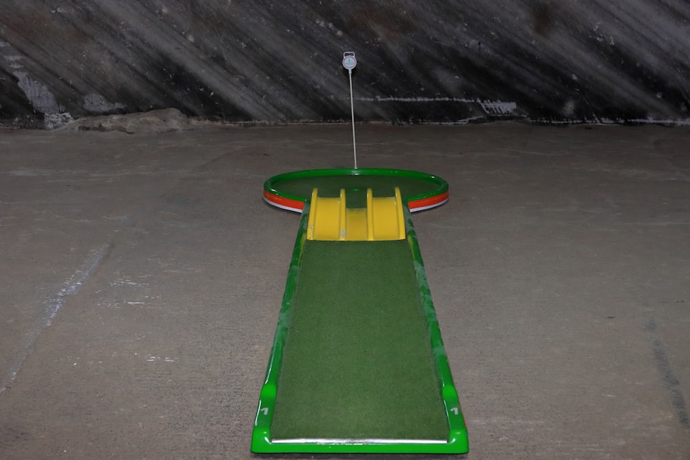 a green and yellow miniature golf course in a parking lot
