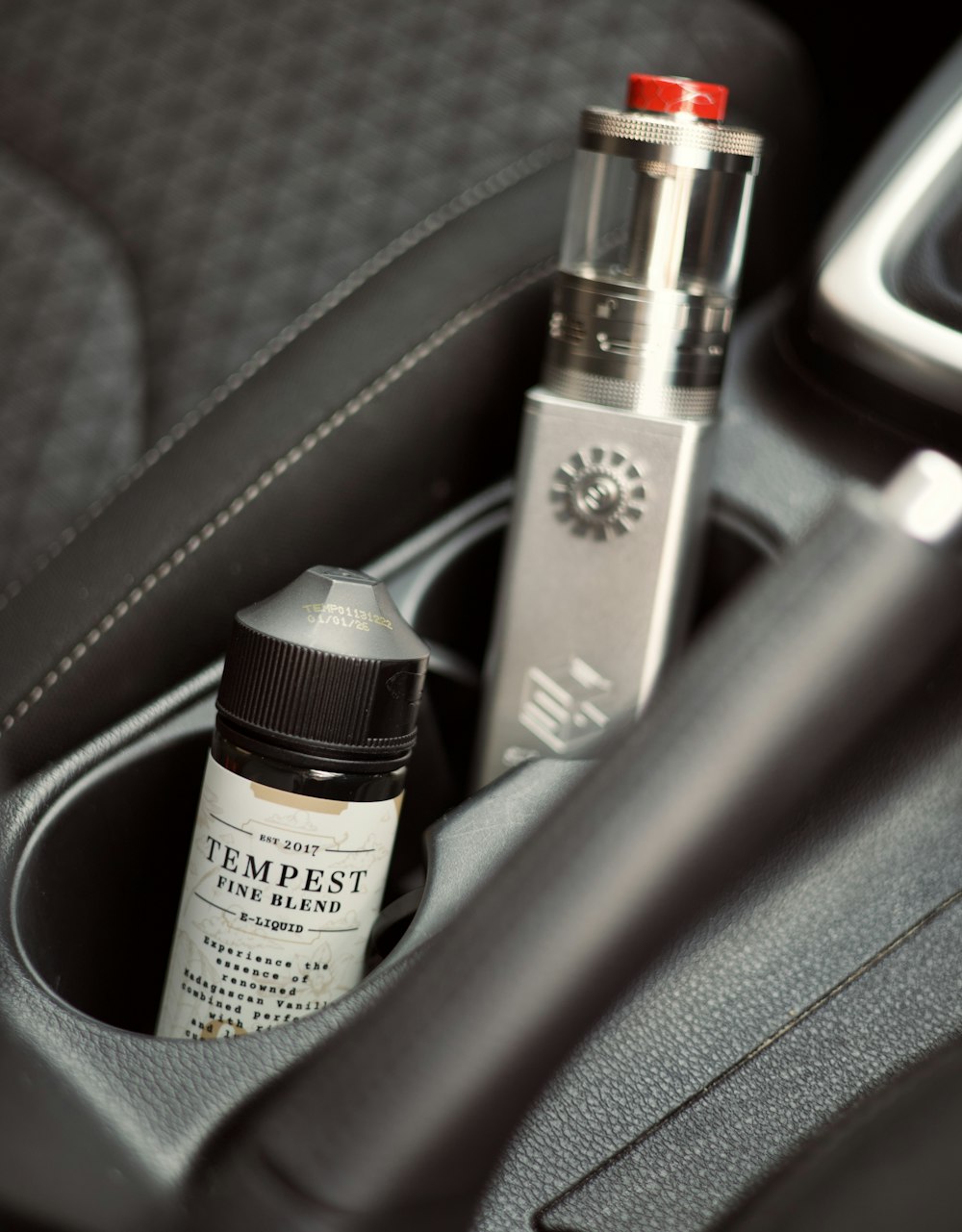 a bottle of perfume sitting in the center console of a car