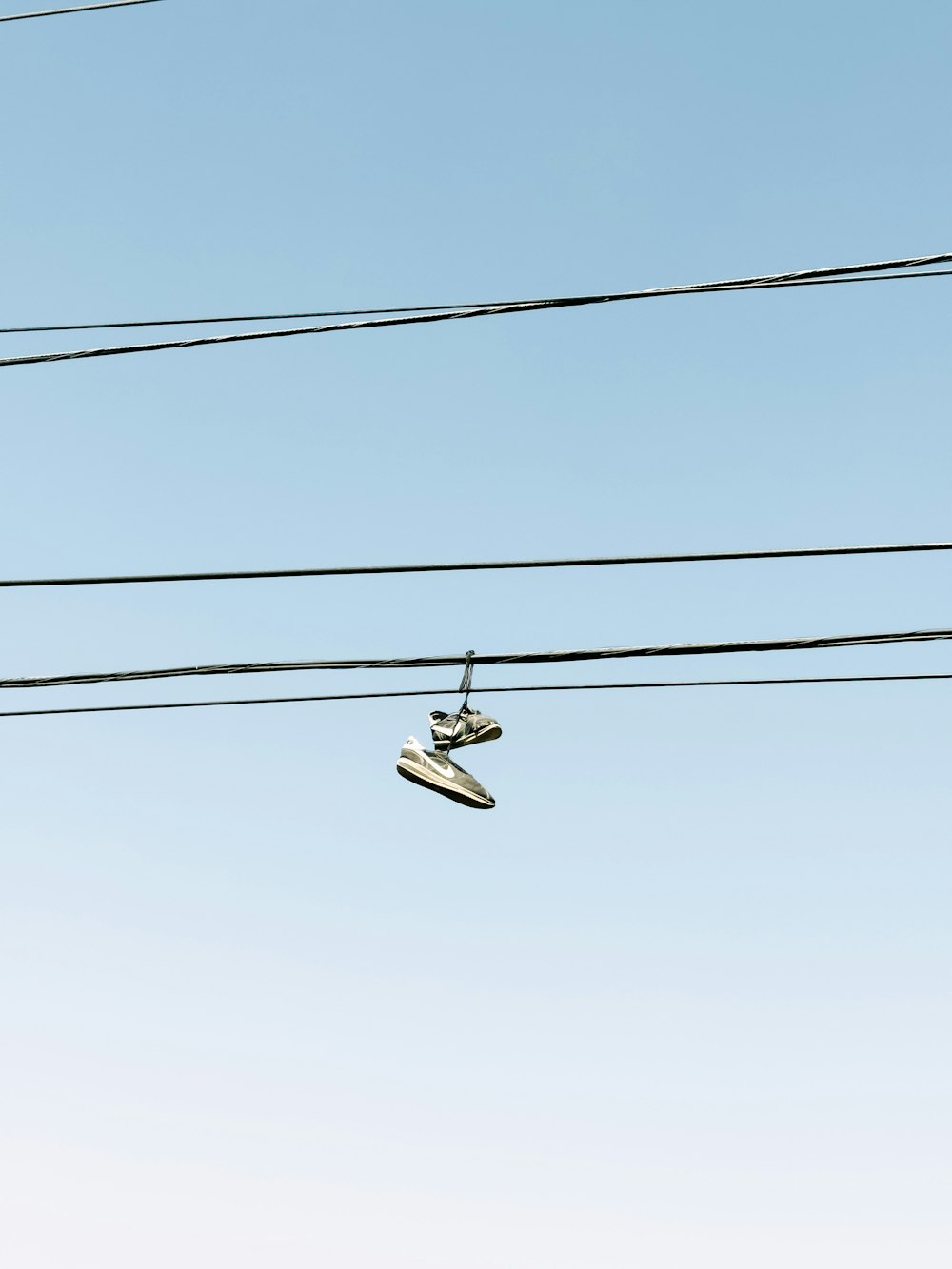 a pair of shoes hanging from a power line