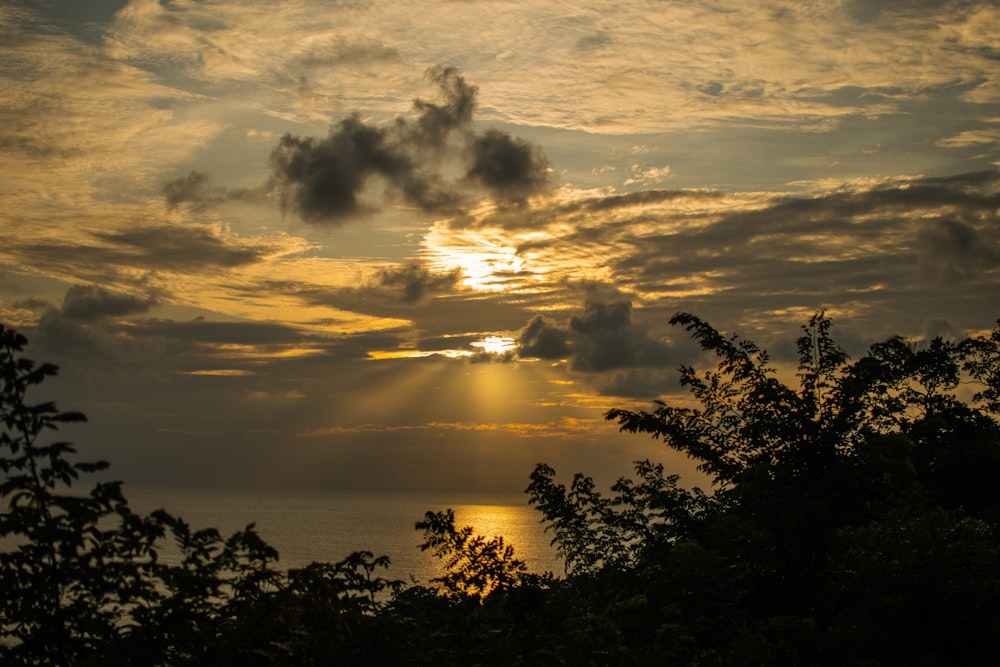 the sun is shining through the clouds over the ocean