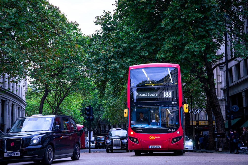 a red double decker bus driving down a street