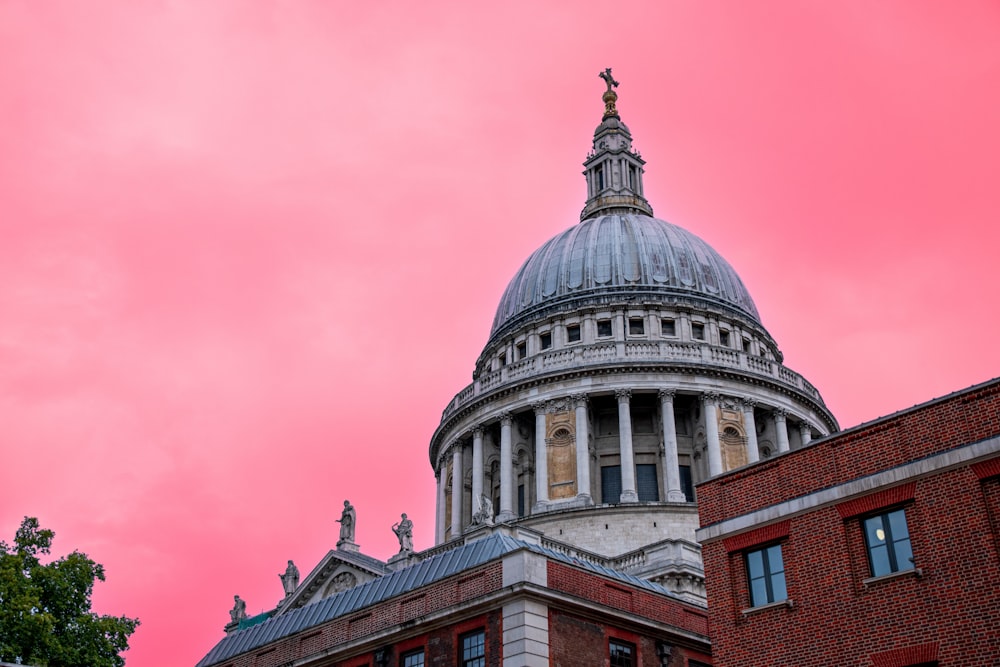 the dome of a building with a pink sky in the background