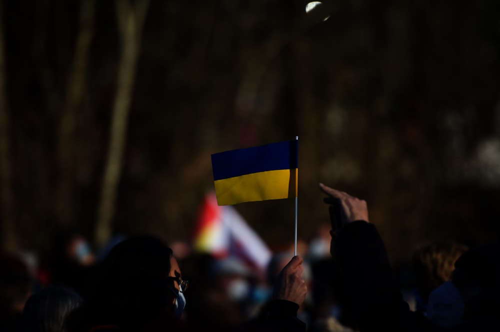 a crowd of people standing around a flag