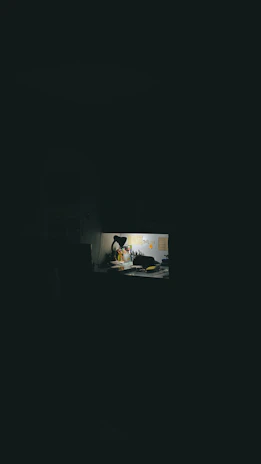 An elegant, dimly lit writing desk with scattered pages and a flickering candle.