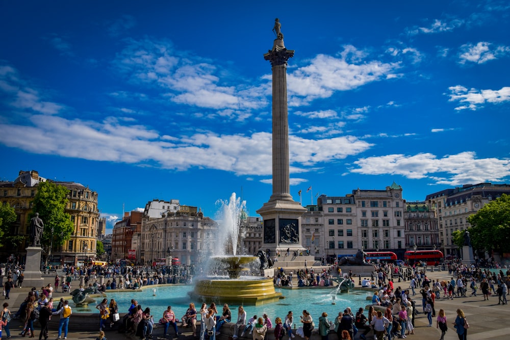 a crowd of people standing around a fountain