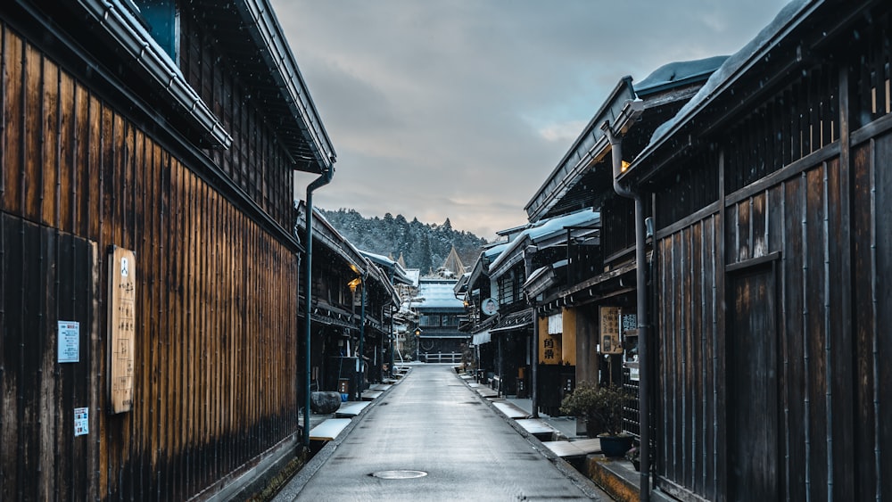 Una calle estrecha con edificios de madera y nieve en el suelo