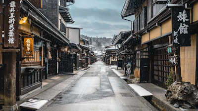 a narrow street in an asian city with snow on the ground