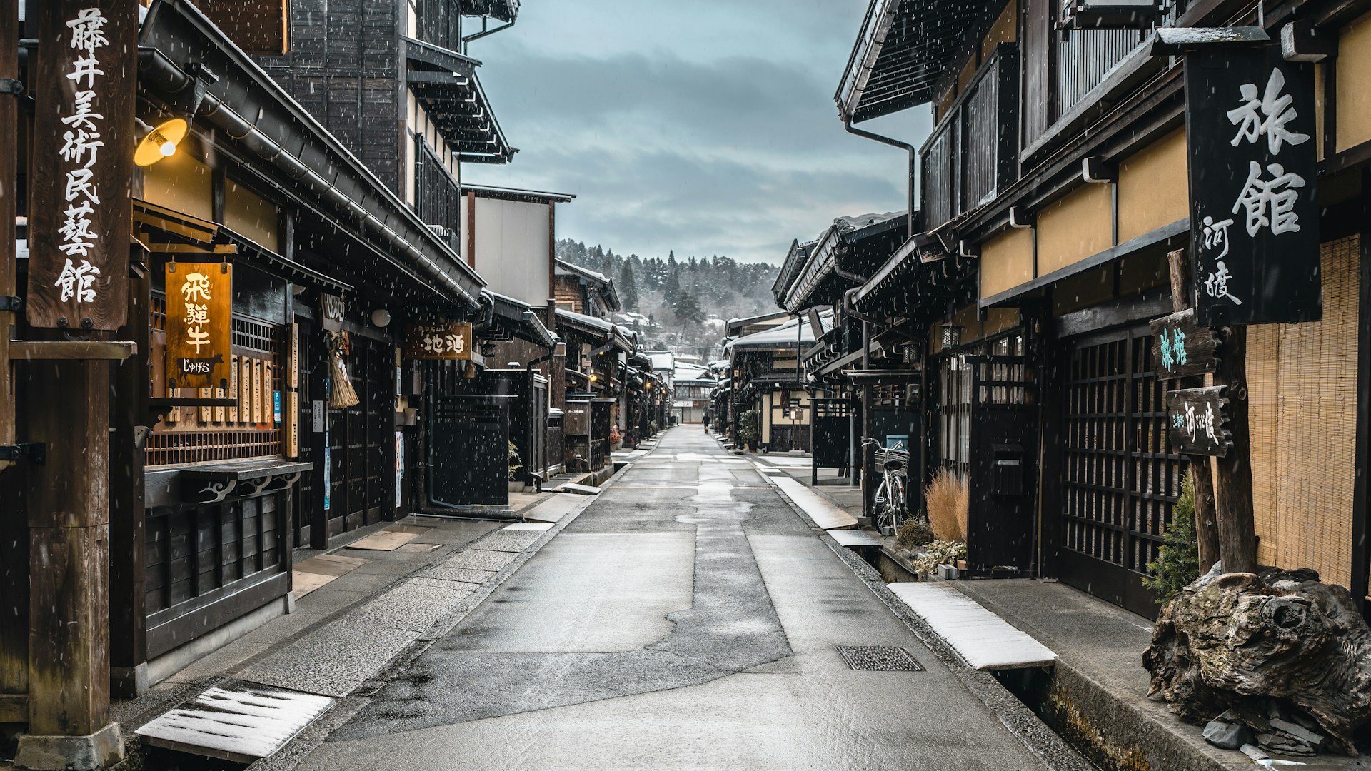 a narrow street in an asian city with snow on the ground