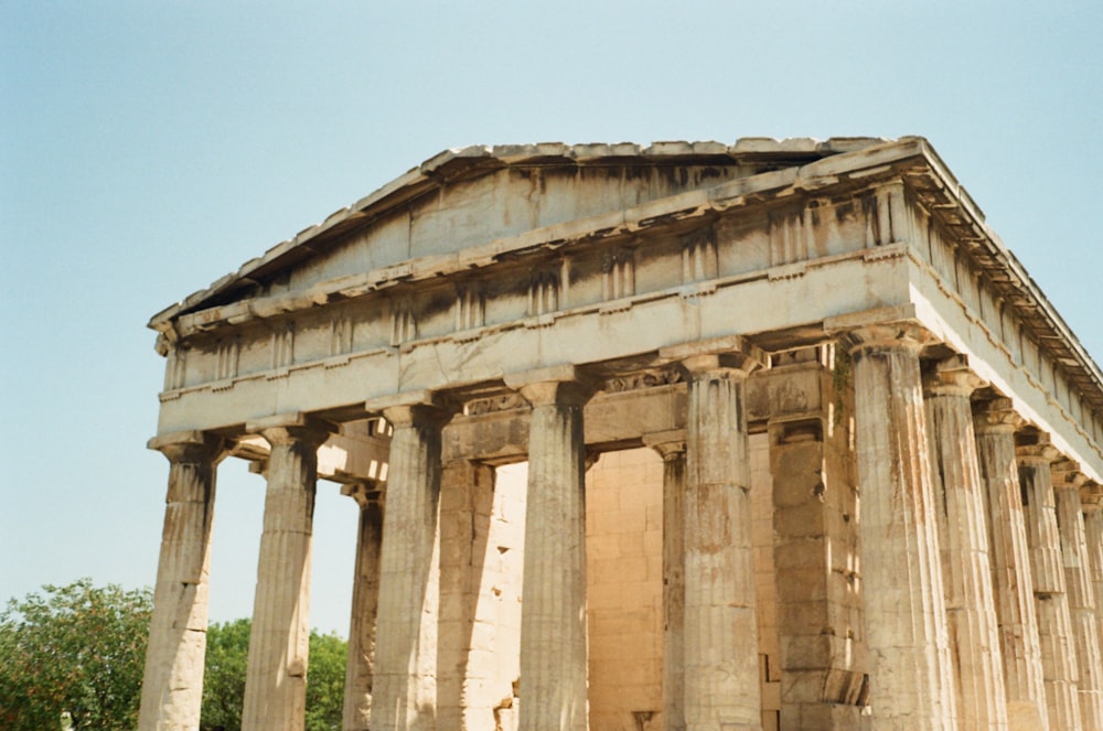 a large stone building with columns and a sky background