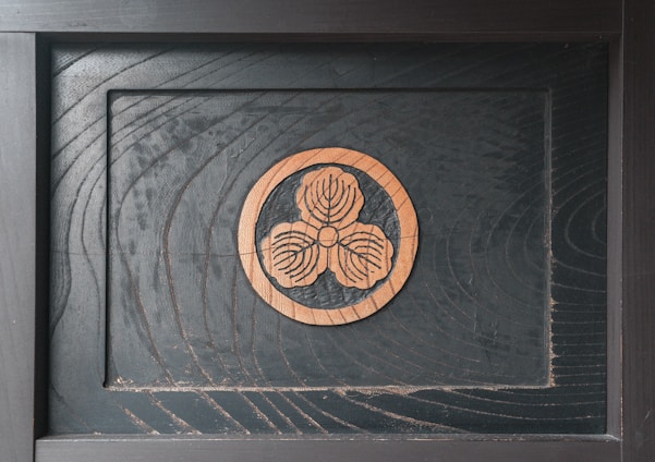 Close-up of a finely laser-engraved wooden plaque with intricate floral patterns.