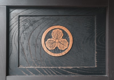 Close-up of a finely engraved wooden plaque with delicate floral patterns.
