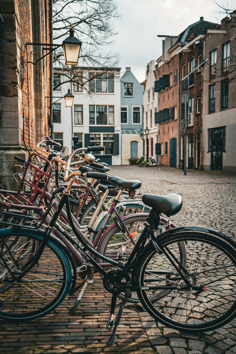 a row of bikes parked next to each other on a cobblestone street