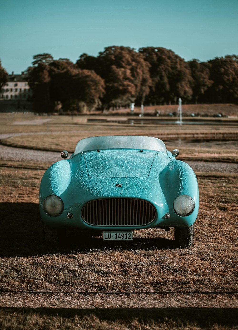 a blue sports car is parked in a field