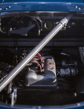 Close-up of a technician testing a car’s wiring harness with specialized tools.