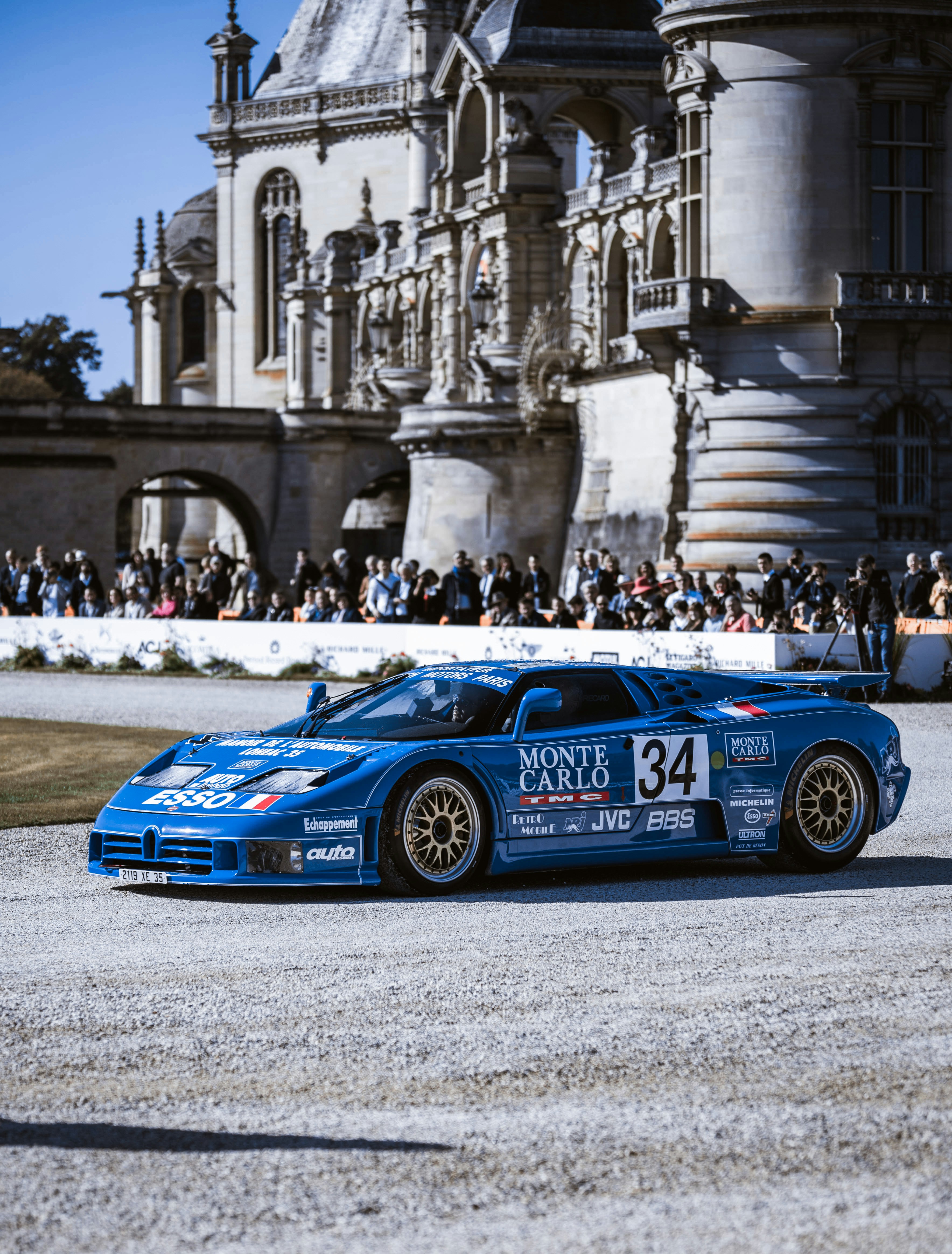 A blue race car driving down a race track photo – Free Car Image on ...