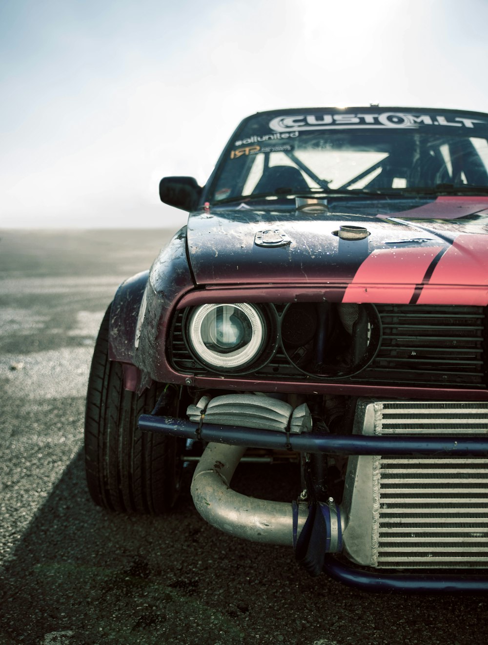 a red and black car with a white stripe on it