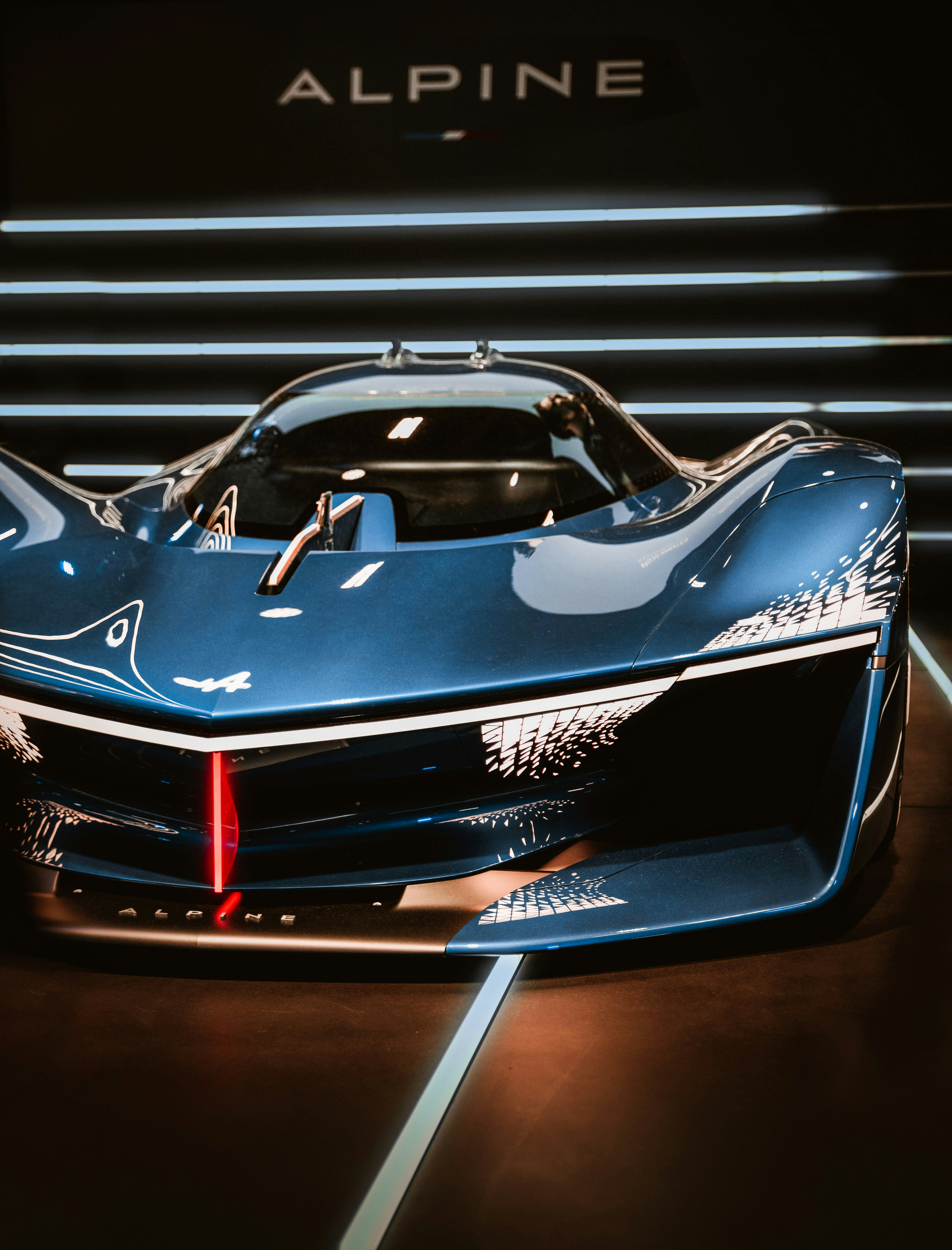 Un auto deportivo azul en exhibición en una exhibición de autos