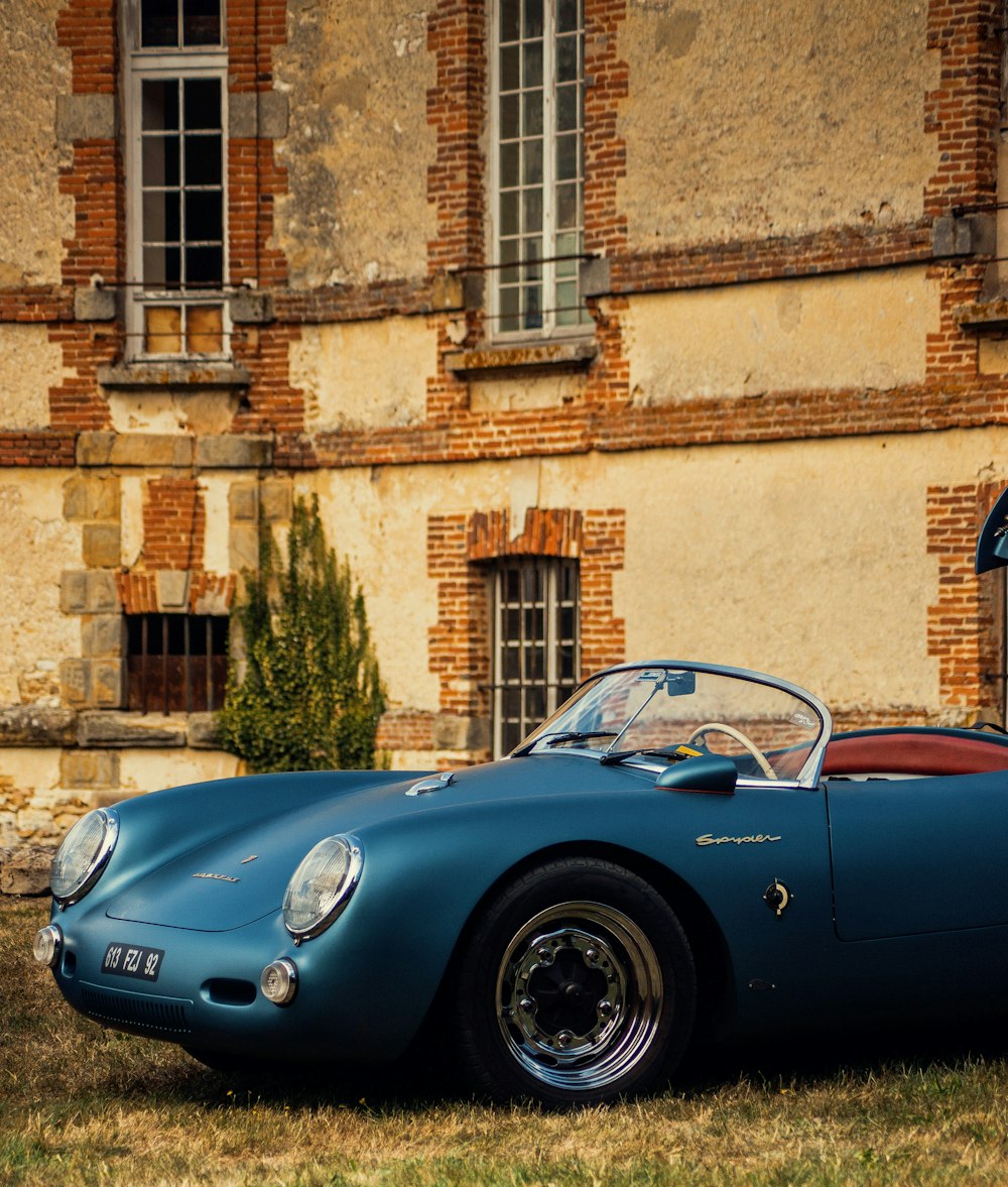 a blue sports car parked in front of a building