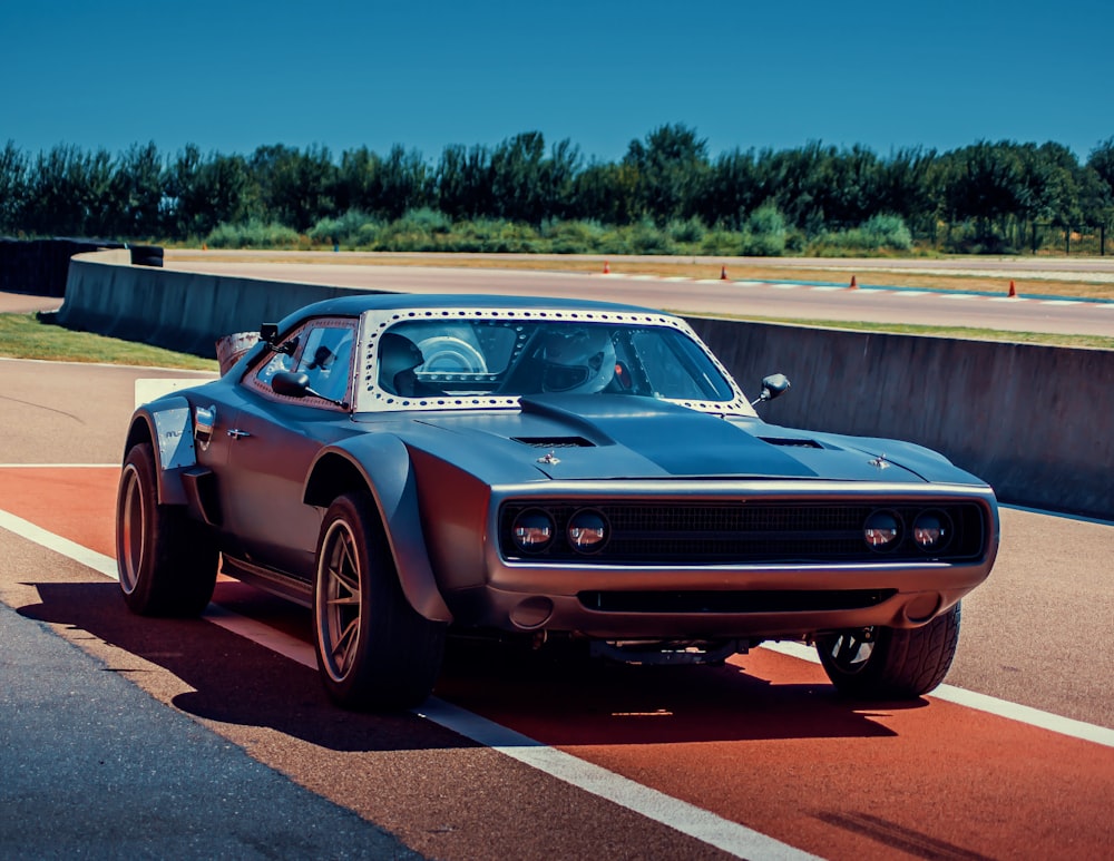 a car driving down a race track on a sunny day