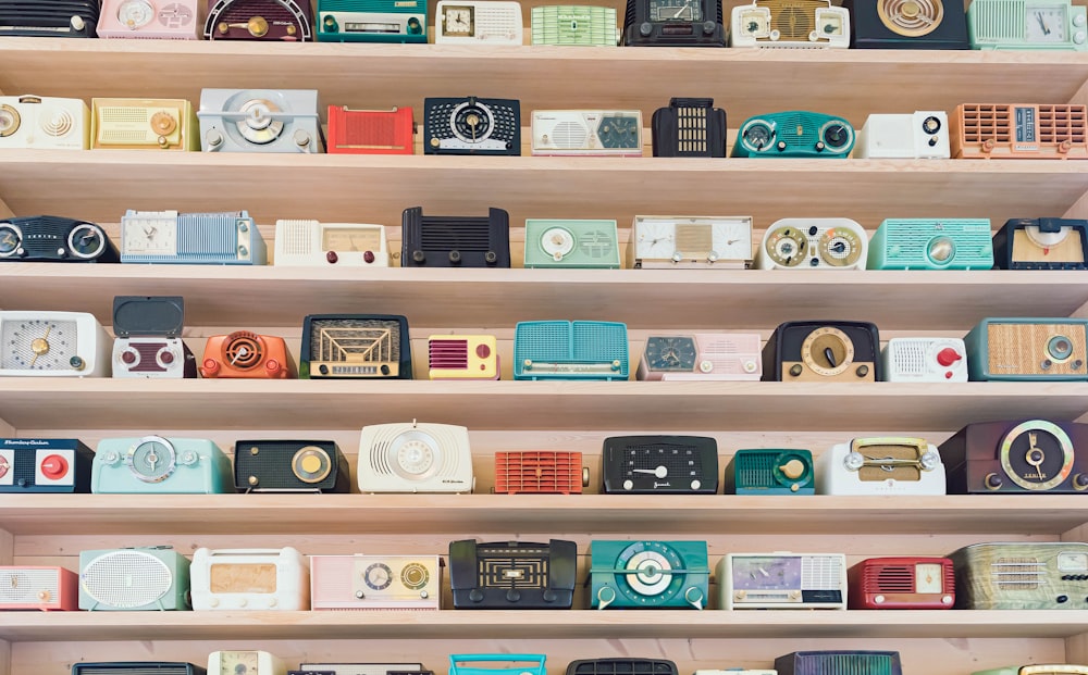 a shelf filled with lots of different types of radio's