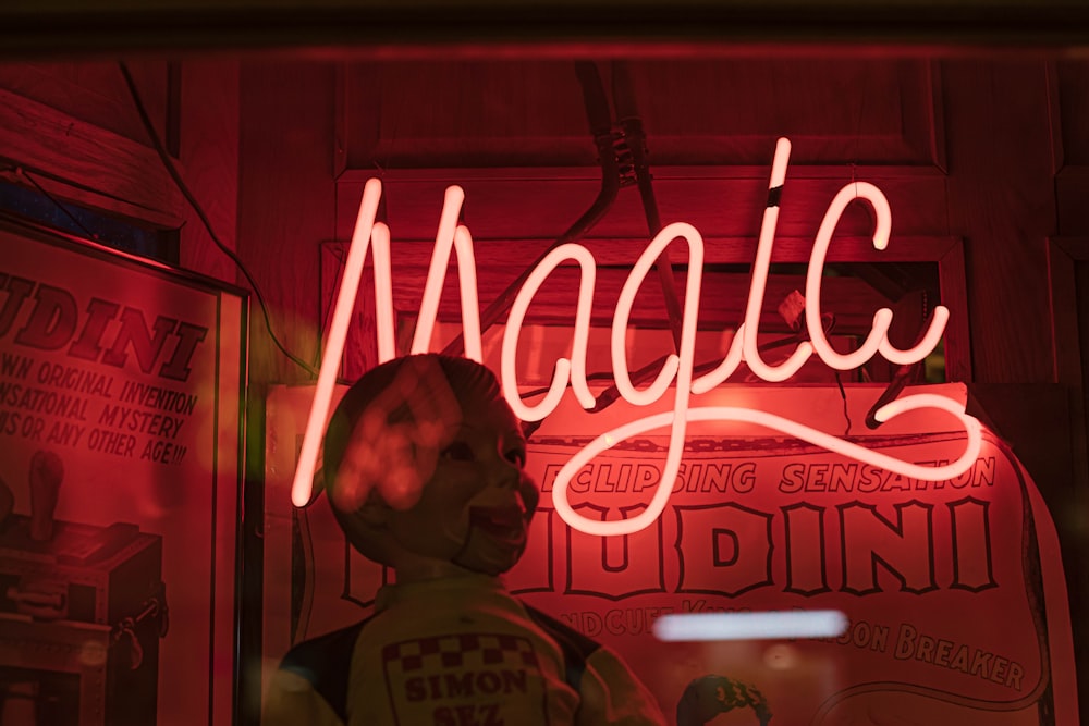 a neon sign that reads magic behind a mannequin