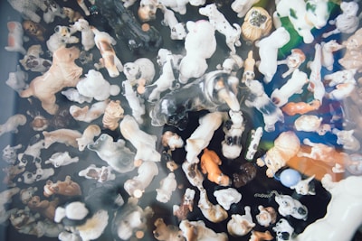 A collection of small, detailed pet figurines arranged artfully on a black velvet cloth.