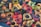 A collection of various colorful plastic objects, including rings, round shapes, and small figurines. The objects are scattered randomly, creating a dense and chaotic arrangement with an assortment of shapes and colors. Some items appear to have small black caps on them.