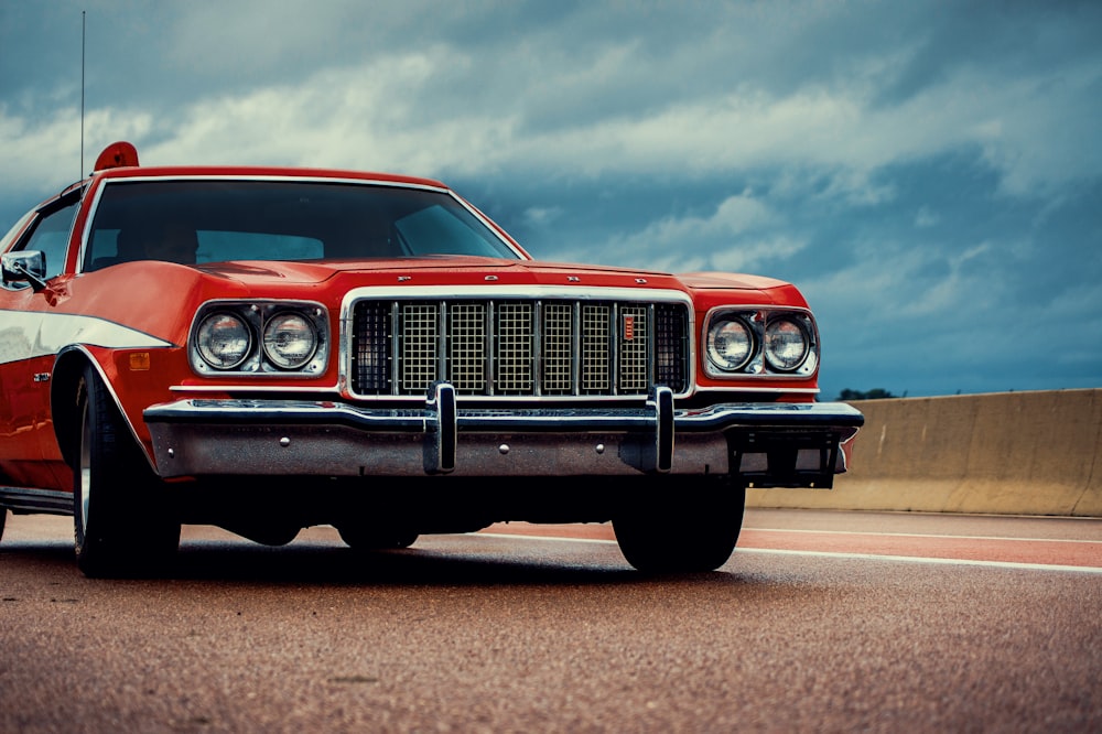 a red car is parked on the side of the road