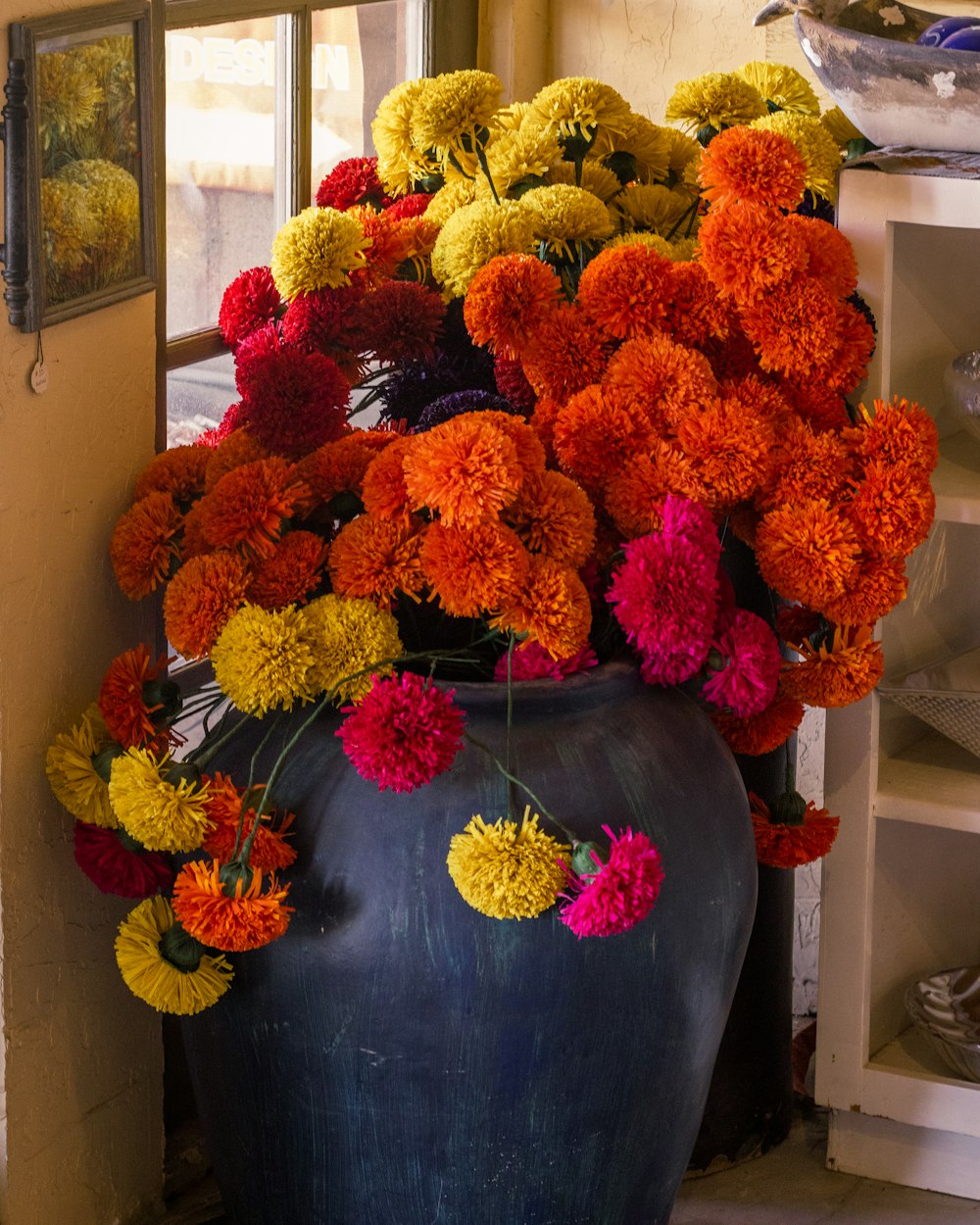 un grande vaso pieno di tanti fiori colorati