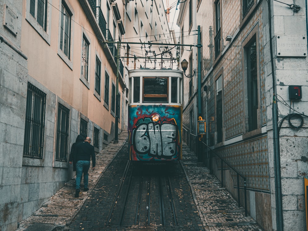 a train traveling down tracks next to a tall building