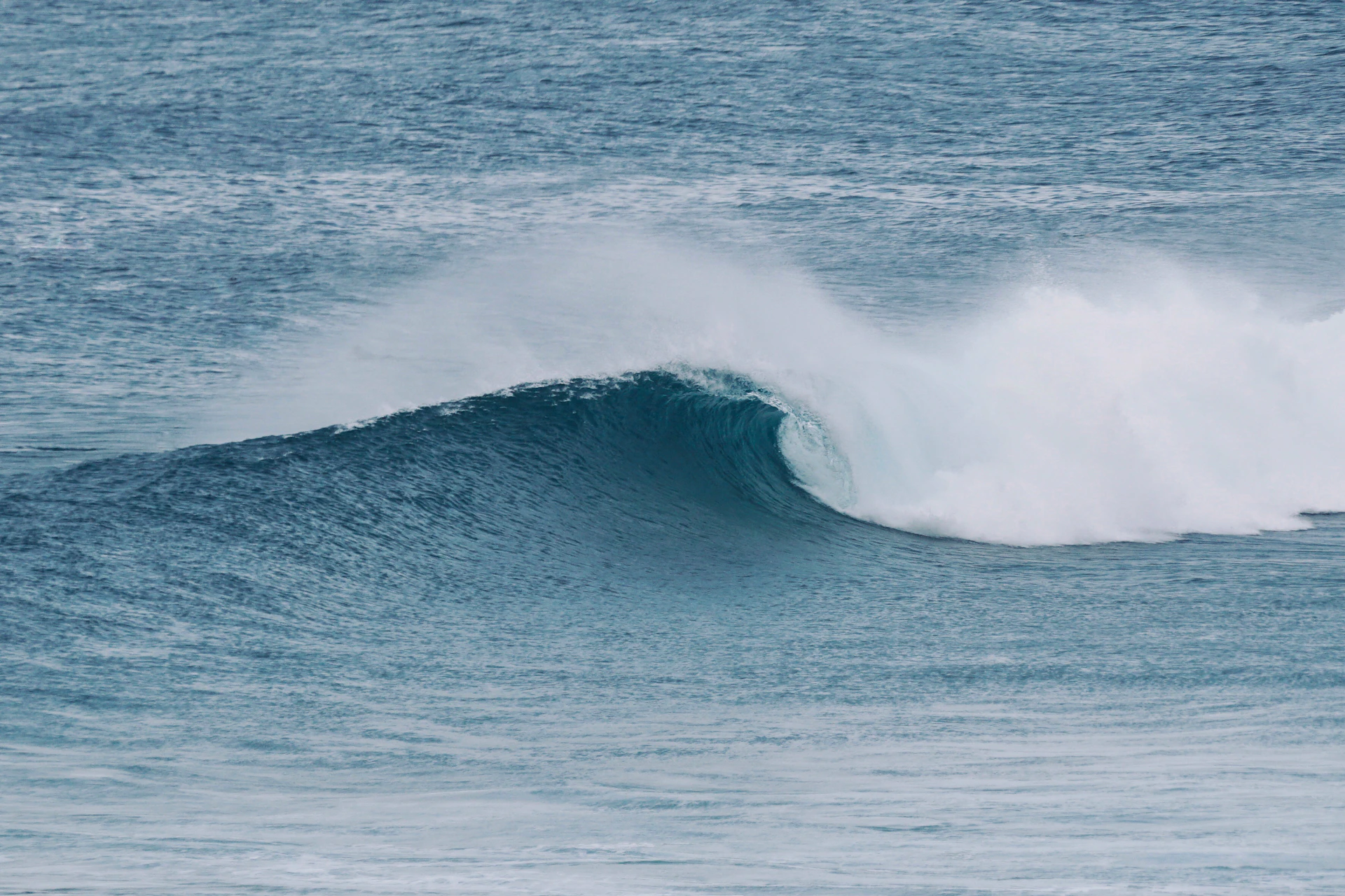 a man riding a wave on top of a surfboard