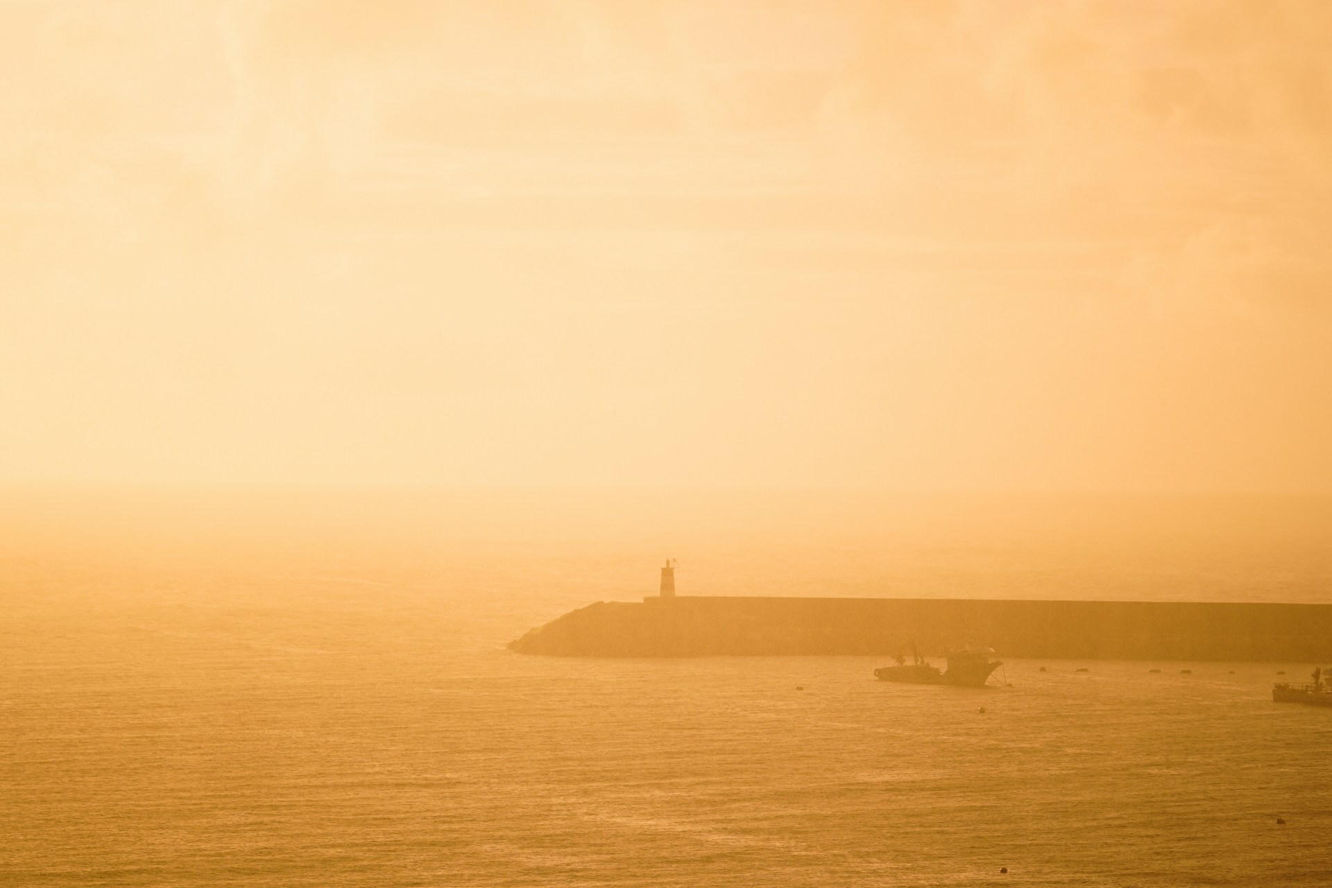 a large body of water with a lighthouse in the distance