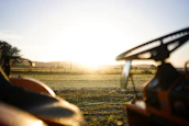 Farm landscape at sunrise with tractors working the land.