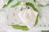 Linen tablecloth with delicate embroidery spread over a farmhouse dining table set for a meal.