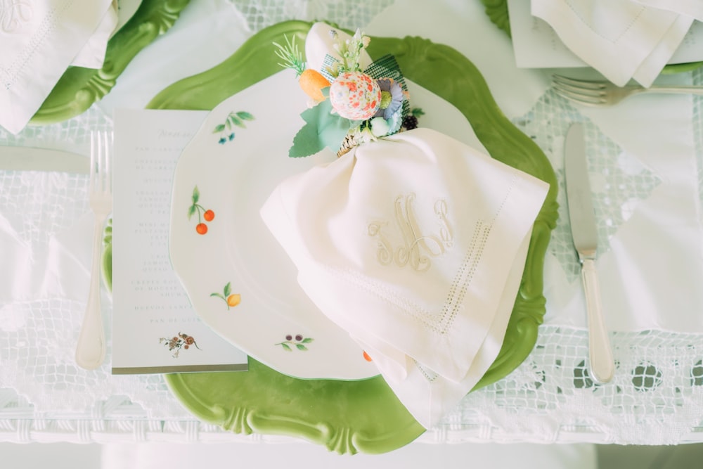 a place setting with a napkin and flowers on it
