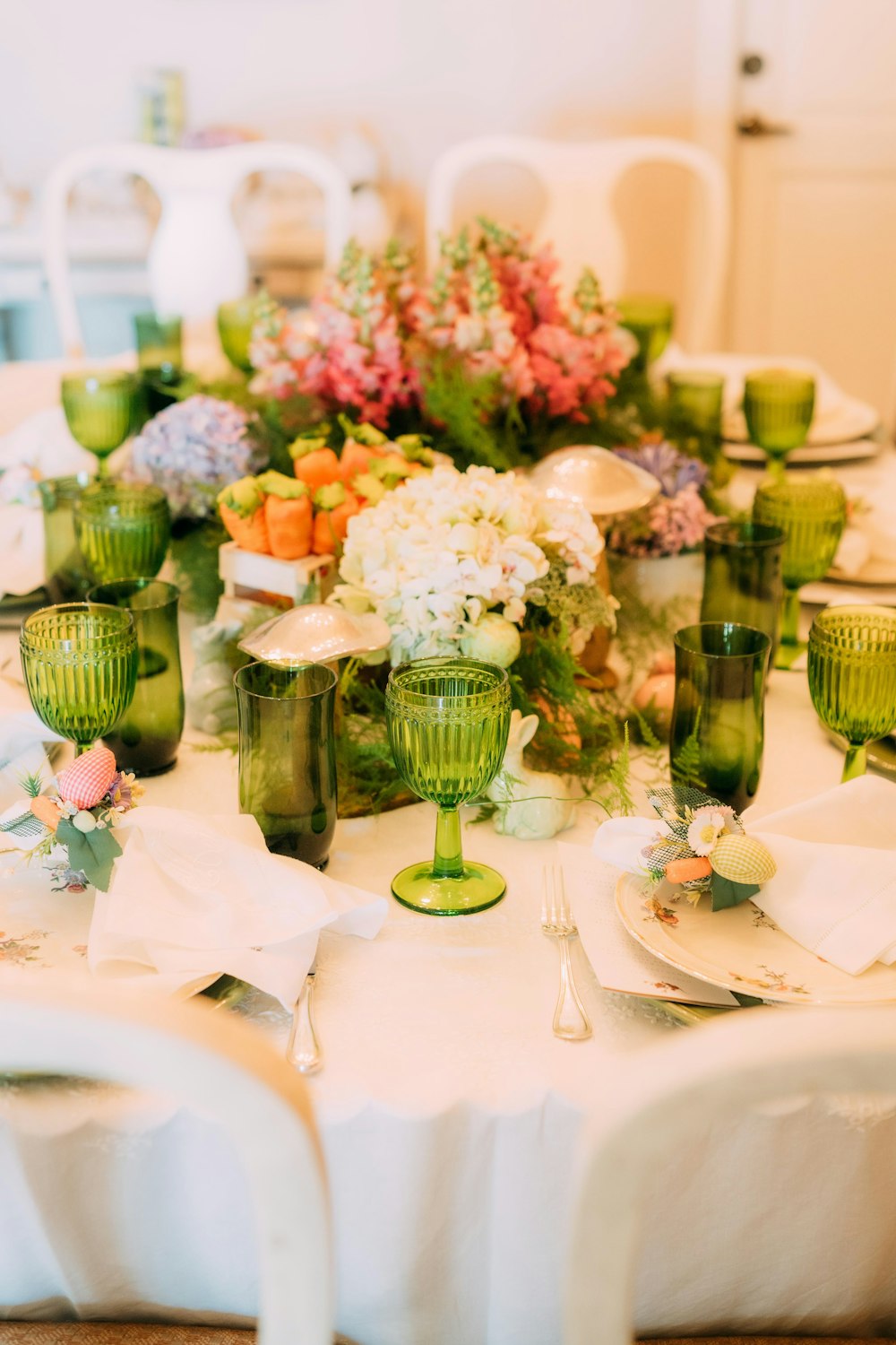 a white table topped with lots of green glasses