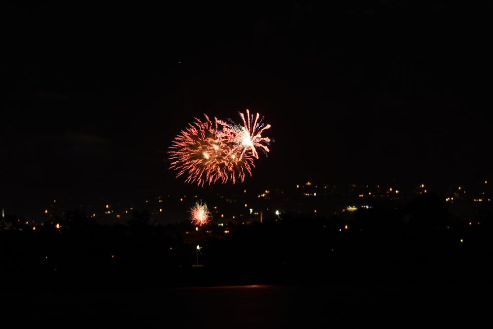 a fireworks display in the night sky over a city