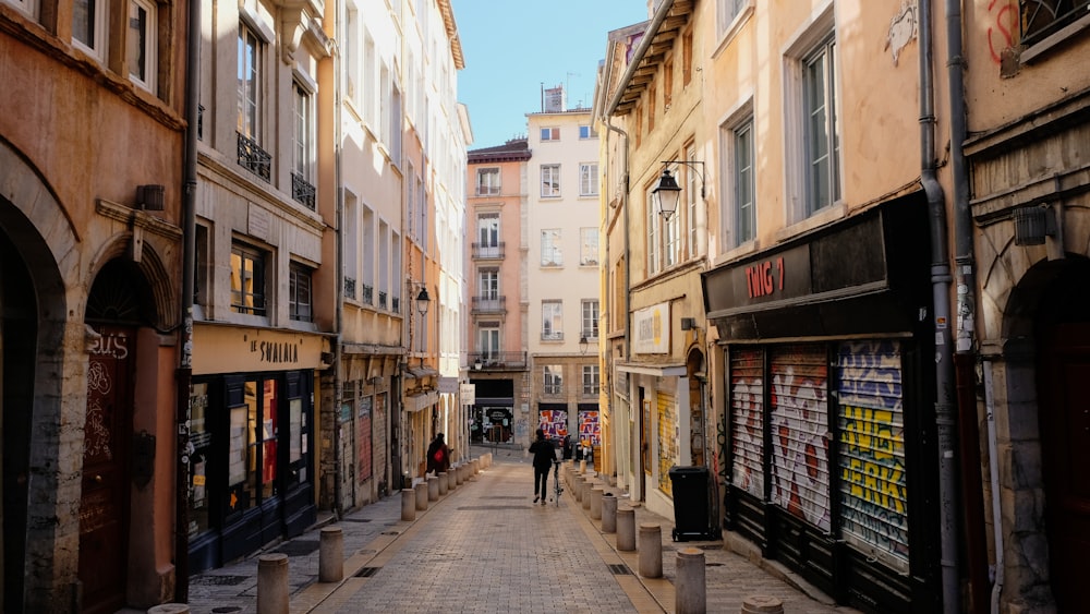 a narrow city street lined with buildings and shops