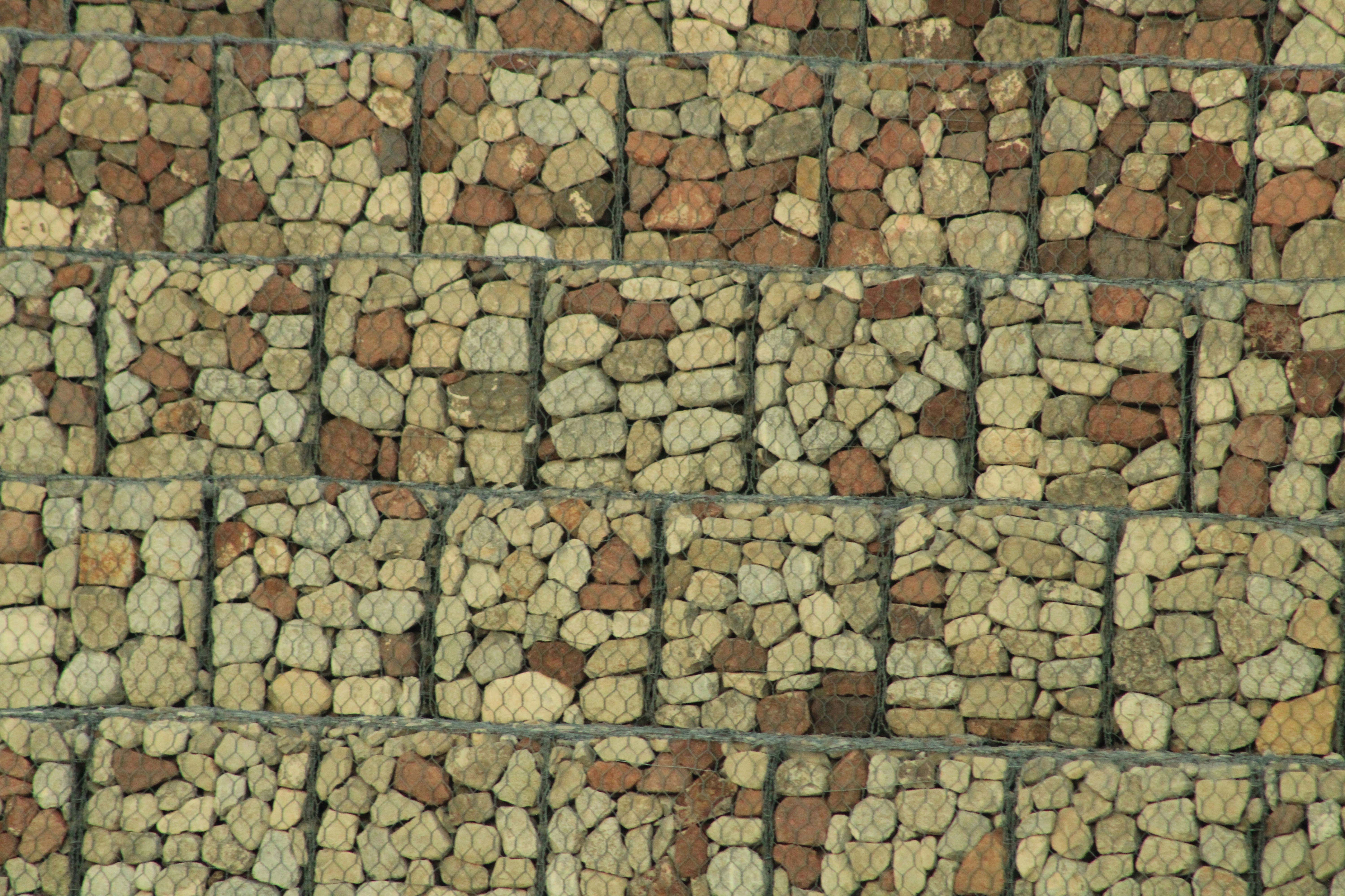 a wall made of rocks with a clock on top of it